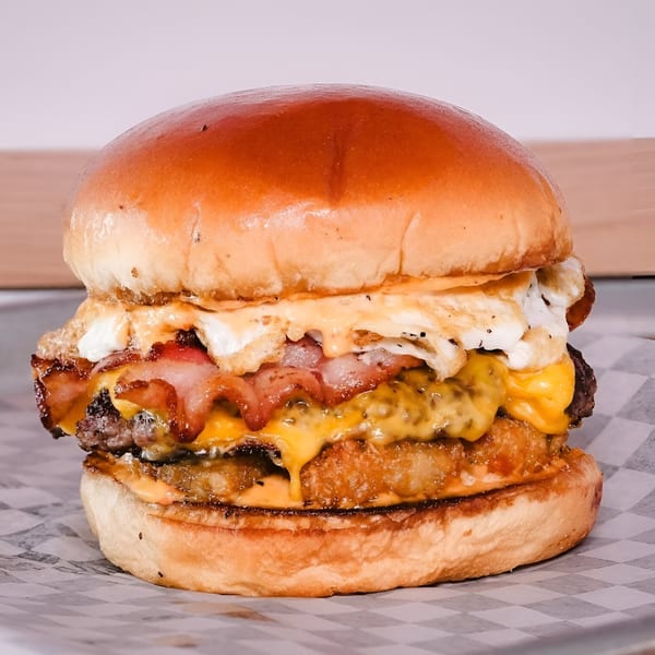 Made Burgers' burger with bacon, melted cheese, fried egg, and hash brown on a bun.